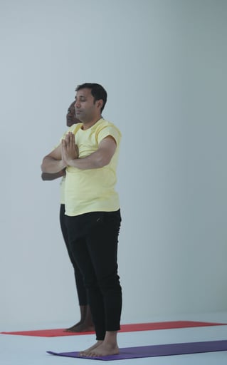 a man doing yoga with yellow shirt and black pants