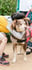 boy bending down to hug a dog in a harness