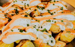 Ración de patatas bravas caseras con salsa brava y alioli del restaurante Santa Lola