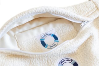 Détail du sac sacoche ÉTOFÉ en tissu recyclé blanc, avec étiquette personnalisée Hôtel du Cap-Eden