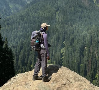 a women with a hiking backpack and hiking boots on a mountain in Kashmir during a hike