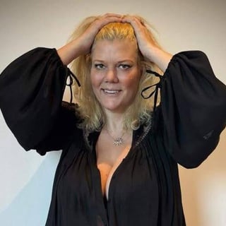 a woman in a black dress and a white wall