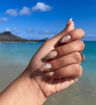 manicure with pale yellow flowers and greens stems and rhinestones for the flower center