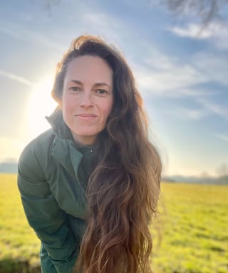 a woman with long hair and a green jacket