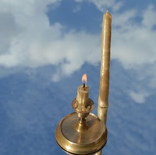 a candle with a candle lite up in the sky