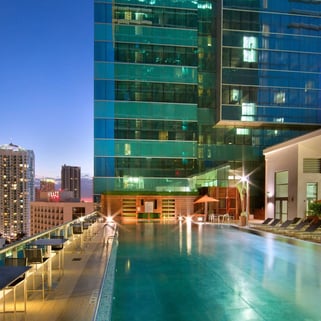 pool JW Marriott Marquis Miami with buildings with lights and the sky in the background in a sunset  