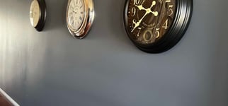 a wall with three clocks