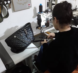 artesã costurando uma bolsa 