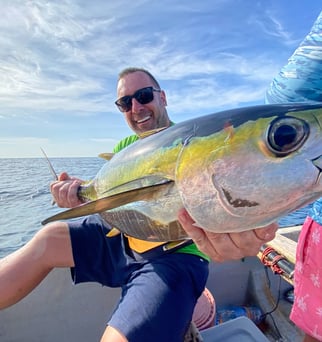 A man holding a fish in his hands during a Zanzibar fishing charter, perfect for Zanzibar fishing