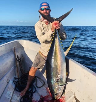 A man holding a Yellowfin Tuna on a boat during a Zanzibar fishing charter, perfect for Zanzibar