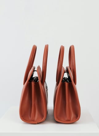 a pair of modern ladies bag on a white table