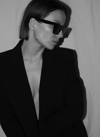a woman in a suit and sunglasses