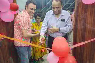 Chief guest cutting a ribbon tied to a ribbon