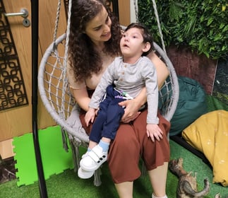 A mother holding her disabled baby in a hammock