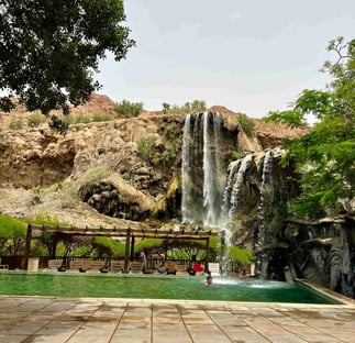 a swimming pool with a waterfall in ma'in hot springs