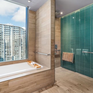 bathroom of the east hotel in miami with the city in the background through the glass
