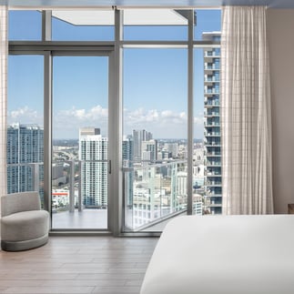 room at the east miami hotel decorated minimalistly with a view of the city of miami in the background through the window