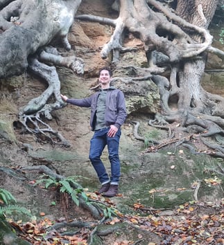 Photo of Rob Wicke, Life Coach, with tree roots in a clay bank as background. Metaphor for grounded.