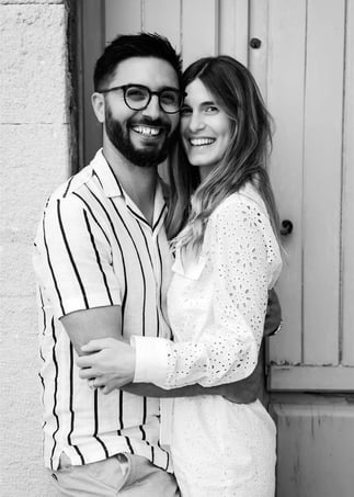 Black and white portrait by Provence engagement photographer — couple in front of village door