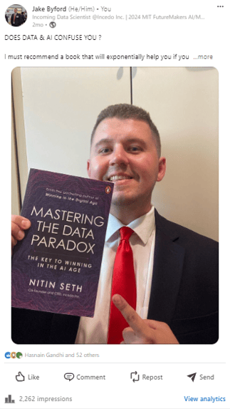 Jake Byford in a suit and tie holding a book titled MAstering the Data Paradox by Nitin Seth