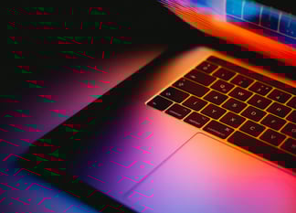 Laptop slightly open with warm colors shining through. Photo by Andras Vas on Unsplash.com