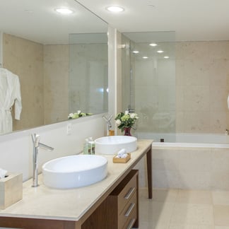 white bathroom at the Miami Vacation Rentals - Brickell hotel, you can see a mirror and a bathtub with a shower