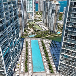 view of the pool at the Miami Vacation Rentals - Brickell hotel, you can see buildings in the background with the beach