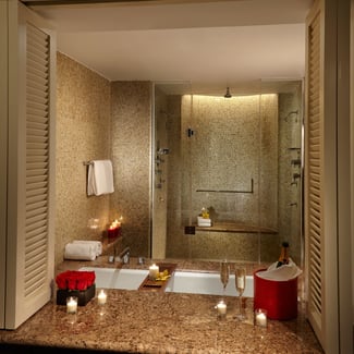 Golden bathroom at the Seminole Hard Rock Hotel and Casino with candles, roses, bottle of champagne, mirror and shower