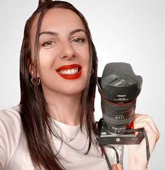 a woman holding a camera and smiling