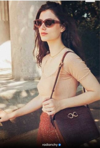 a woman in a short sleeved top and sunglasses