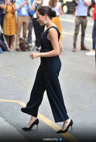 a woman in a black dress and heels