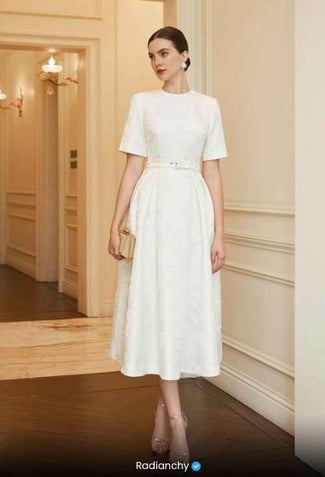 a woman in a white dress with a purse