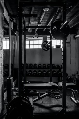 O sală de fitness dotată cu o bancă și o bară de greutăți.