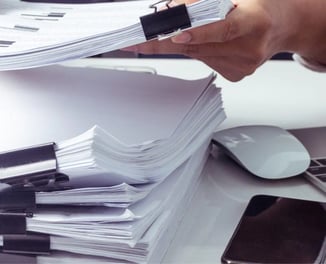 a person sorting documents to create a report