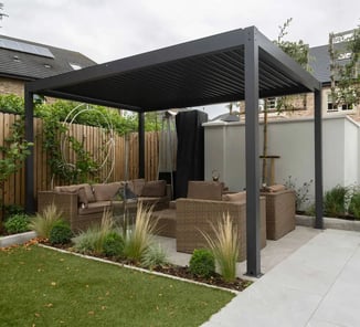 Pergola autoportée en aluminium gris avec lames orientables, installée dans un jardin moderne.