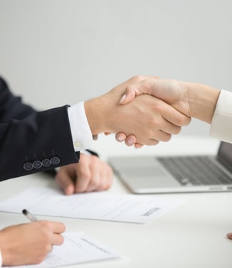 pharmacovigilance experts concluding a pharmacovigilance agreement and shaking hands