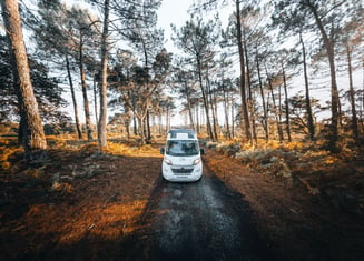 a white car parked on a dirt road