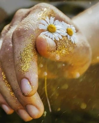 Main recouverte d'or avec une fleur magnifique