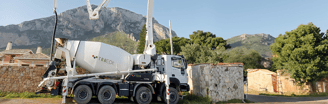 a cement mixer truck with a man standing next to it