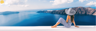 a woman sitting on a ledge overlooking a view of a lake