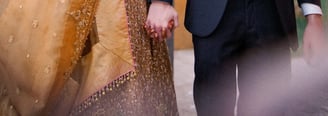 a man and woman holding hands and walking through a doorway