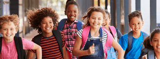 a group of children and adults walking down a hallway