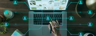 a person using a laptop computer and a pen