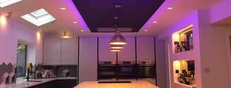 a kitchen with a table and chairs and a purple light