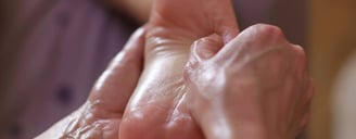 Massage du pied, geste lent et précis pour relâcher les tensions et inviter au lâcher-prise.