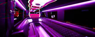 The inside of a party bus limo with pink neon