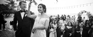a bride and groom are standing in front of a crowd of people