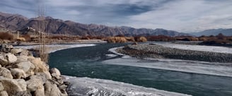 a river with ice and snow on the ground