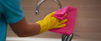 Technicien de M & M Services Pro nettoyant une robinetterie chromée avec un chiffon rose à Rouen
