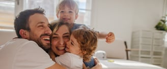 família feliz com um casal e duas crianças protegidas e felizes - seguro de vida, proteção, abraço